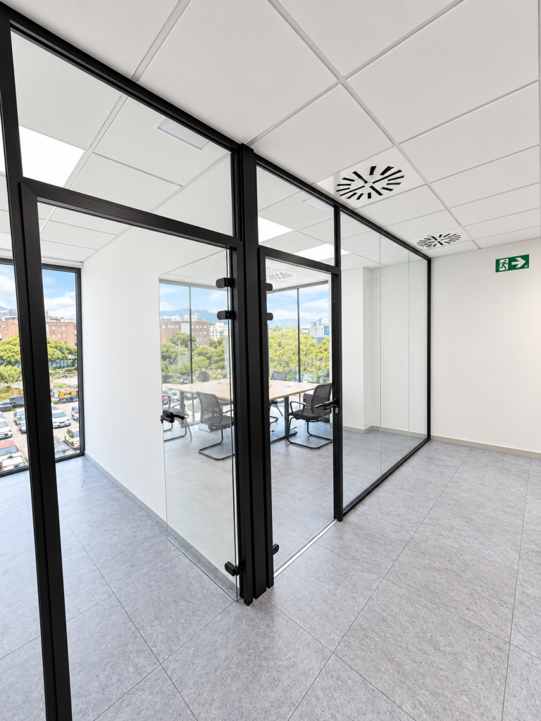 Puerta de cristal con perfilería negra entre despachos acristalados – proyecto Bellper en Castelldefels